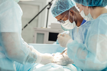 stressful occupation. serious african doctor focused on his work. close up side view photo