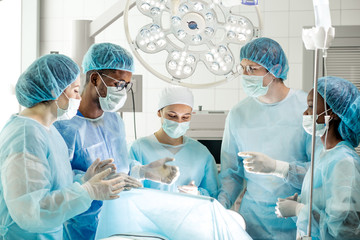 diverse medical specialists making decision in the operating room