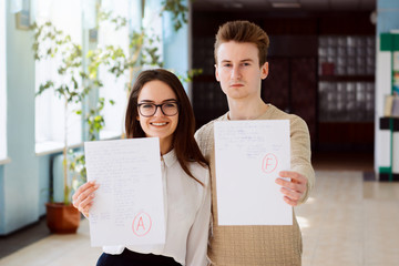 Concept of exam, final test. Two students received result of their test. Female student got...
