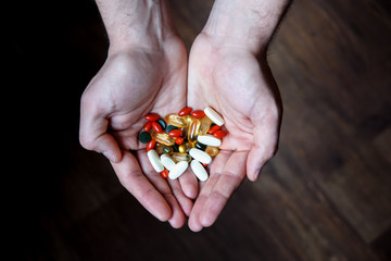 healthy lifestyle, medicine, nutritional supplements and people concept - close up of male hands holding pills 