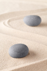 Fototapeta na wymiar Zen meditation stone in Japanese zen garden. Concept for spirituality, concentration and purity on a minimal sand background..