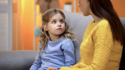 Mom having serious conversation with girl, explaining kid mistakes in behavior