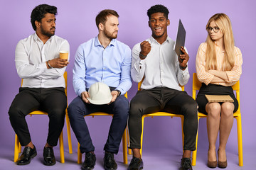 Obraz premium upset and disappointed multicultural young people after job interview and happy dark-skinned man who successfully passed
