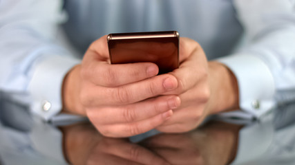 Businessman hands holding luxury gadget, browsing internet on phone, work app