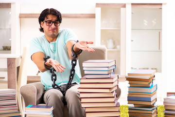 Male student with many books at home 