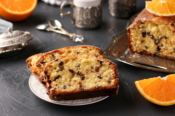 Cupcake with oranges and chocolate located on a tray against a dark background