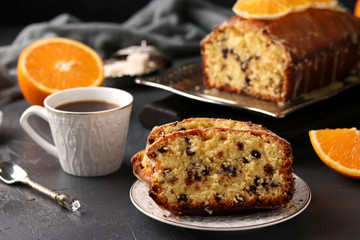 Cupcake with oranges and chocolate located on a tray against a dark background