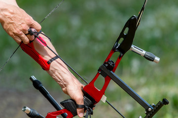 Archer pulls on the sport bow string, taking aim at his target at the competition