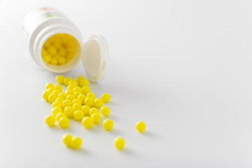 yellow pills of vitamins on a white background for the treatment of diseases in the hospital