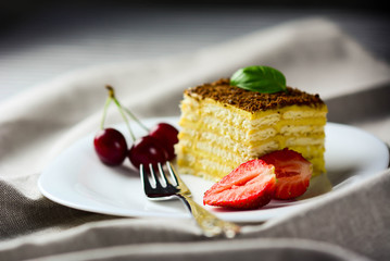 Various cake pieces of chocolate and vanilla filling.Basil, cherries and strawberries.