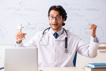 Young male doctor neurologist in front of whiteboard 