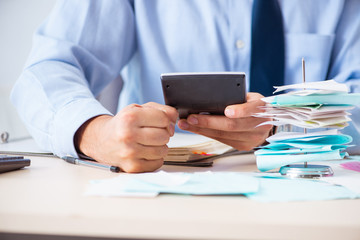 Young handsome businessman in budget planning concept 