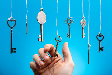 Person's Hand Choosing Hanging Key