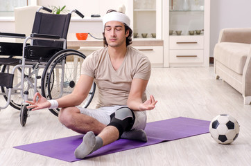 Fototapeta na wymiar Injured young man doing exercises at home 
