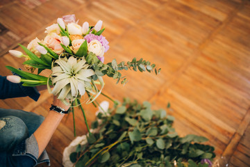 Obraz na płótnie Canvas Florist girl makes a bouquet. Florist Workflow. The girl collects a bouquet