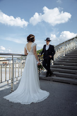 Caucasian happy romantic young couple of groom and bride on the stairs near river