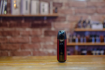 Electronic cigarette on a background of vape shop. E-cigarette for vaping. Popular vape devices