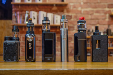 Electronic cigarette on a background of vape shop. E-cigarette for vaping. Popular vape devices