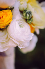 wedding bouquet with white carnations and ranunculi. delicate bouquet in yellow and white. eucalyptus leaves.
