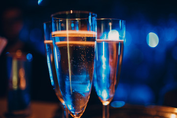 Glasses with champagne in a multi-colored light at a party