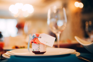 served table with white tablecloth. white plates, wine glass, fork, knife