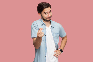 Portrait of funny handsome bearded young man in blue casual style shirt standing and looking at...