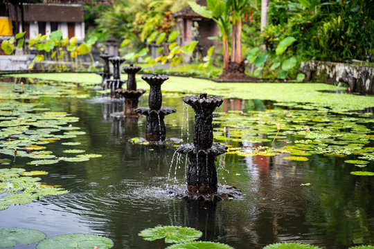 Water Palace of Tirta Gangga, Karangasem, Indonesia. Popular beautiful water palace with fountains and traditional hindu demons statues. Smaller lily fountains and water lilies.