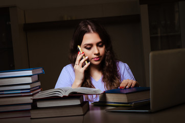 Young female student preparing for exams late at home 