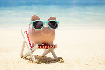 Pink Piggybank With Sunglasses On Deck Chair At Beach