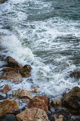 Seascape, seafoam of storm on wild rocky seashore