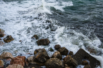 Seascape, seafoam of storm on wild rocky seashore