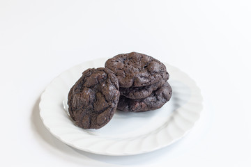 Double chocolate chip cookies on white plate isolated on white background