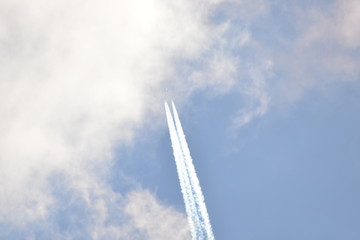 airplane with contrail in sunny sky at very high altitude
