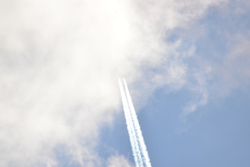 airplane with contrail in sunny sky at very high altitude