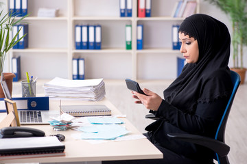 Obraz na płótnie Canvas Female employee bookkeeper in hijab working in the office 
