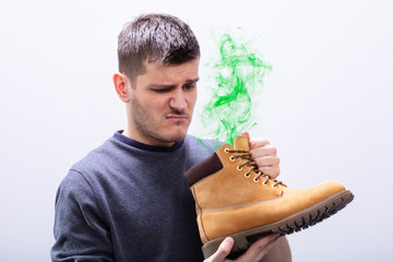 Man Holding Stinky Shoes