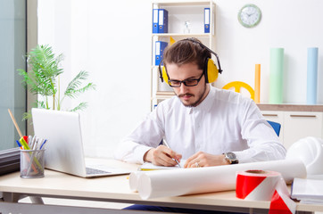 Young male architect working in the office 