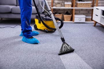 Person Cleaning Carpet With Vacuum Cleaner