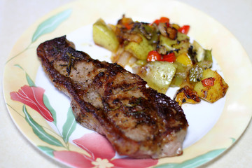 NY strip steak with potatoes on a plate.