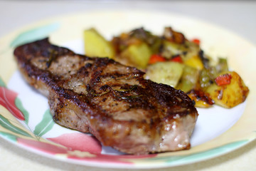 NY strip steak with potatoes on a plate.