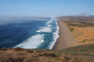 Waves breaking on the beach at Point Reyes National Seashore in Northern California, with fog beginning to roll in from the Pacific Ocean.