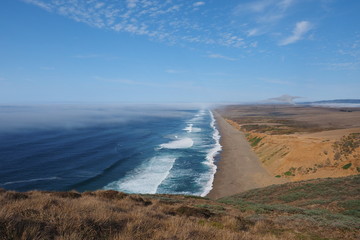 Waves breaking on the beach at Point Reyes National Seashore in Northern California, with fog beginning to roll in from the Pacific Ocean.