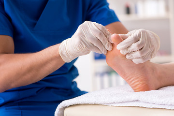 Podiatrist treating feet during procedure