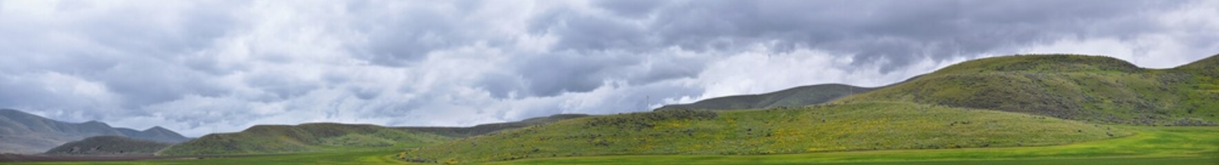 Landscape stormy panorama view from the border of Utah and Idaho from Interstate 84, I-84, view of rural farming with sheep and cow grazing land in the Rocky Mountains. United States.