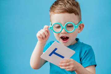 Cute little boy with letter on background. Child learn letters. Alphabet