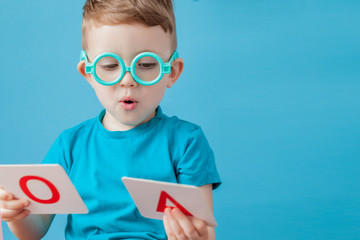 Cute little boy with letter on background. Child learn letters. Alphabet