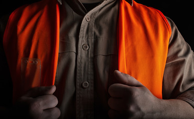 Worker in orange jacket outfit closeup.