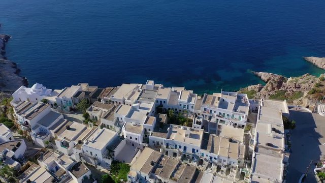 Aerial drone video of picturesque whitewashed steep cliff church of Panagia Pantanassa in main village of Folegandros island with stunning views to deep blue Aegean sea, Cyclades, Greece