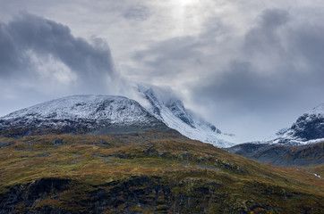 Landscape of snowy mountains and cloudy sky in Norway in summer