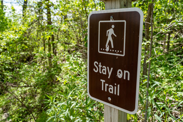 Sign warning and reminding hikers to stay on the trail